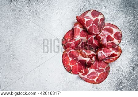 Coppa Cured Ham On Kitchen Table. White Background. Top View. Copy Space