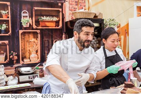 Moscow, Russia, July 13, 2019: An Italian Chef In Uniform Fills A Cream Cone With Cannoli Siciliani 