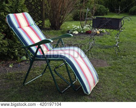 Chaise Longue And Alit Coals In Chargrill. In Expectation Of Barbecue. Idyllic Landscape