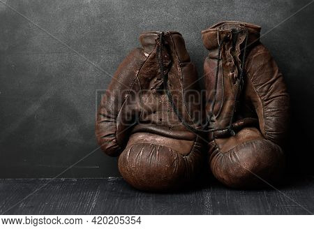 Brown Leather Vintage Boxing Gloves On A Black Background, Sports Equipment