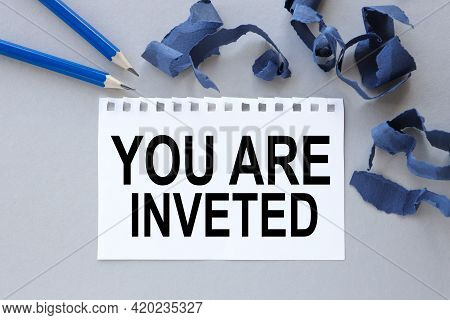 You Are Inveted. Text On White Notepad Paper. Near Torn Blue Paper