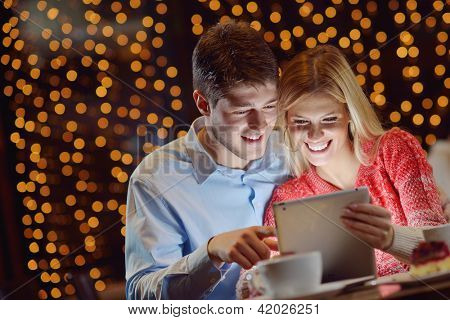glade unge par med en tablet computer i restaurant