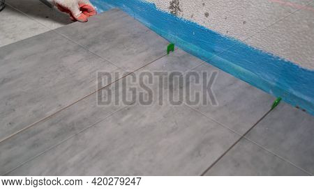 Installing Ceramic Tiles On The Floor. Home Improvement, Renovation - Construction Worker Tiler Is T