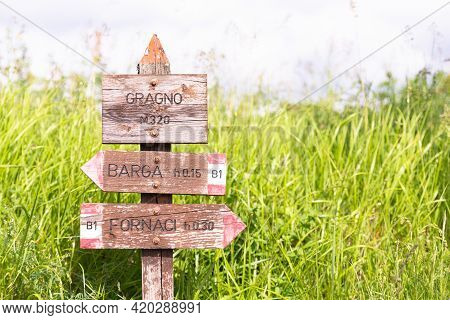 Wooden Plaque In The Mountains Of Tuscany. Homemade Signpost Of Localities Near Barga.