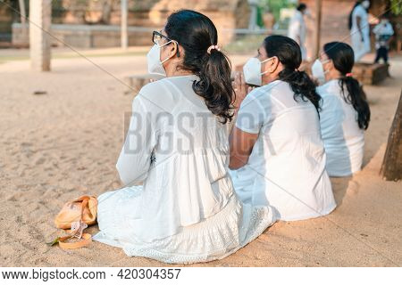 Buddhist Female Devotees Worshipping At Jaya Sri Maha Bhodi While Sitting On The Sandy Soil In White