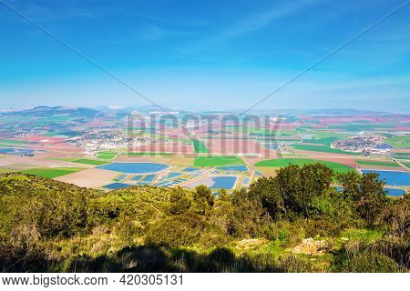 Jezreel Valley in the Lower Galilee, Israel. The valley is now occupied by fertile farmland belonging to kibbutzim, moshavim and Arab villages. Warm winter in israel. Picturesque agricultural fields 