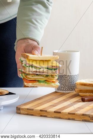 Hands Hold Cooked Fresh Sandwich With Cheese, Bacon And Vegetable Cup Of Coffee Or Tea