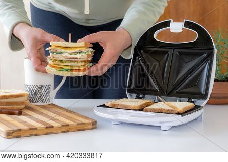 Hands Hold Cooked Fresh Sandwich With Cheese, Bacon And Vegetable Near Toster And Cup Of Coffee