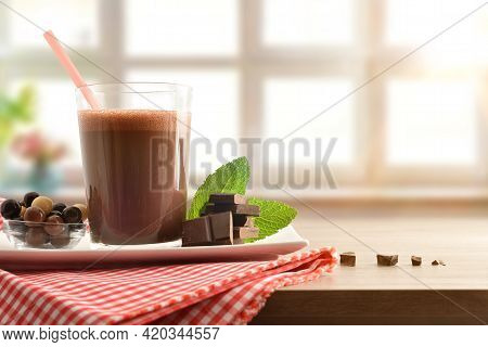 Glass With Milk Chocolate Shake On Serving Plate With Bowl Full Of Cocolate Balls And Portions On Re