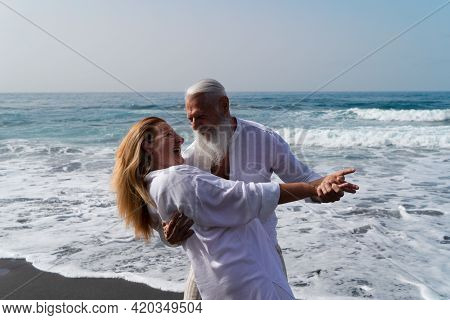 Lifestyle With Smiling Caucasian Senior Couple Dance On Beach, Happy In Love Romantic And Relax Time
