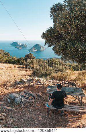 The Tourist Seating, Reaching The Path To The Lighthouse. View Of The Lighthouse Helidonia From The 
