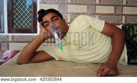 Young Man Infected With Covid 19 Disease. Patient Inhaling Oxygen Wearing Mask With Liquid Oxygen Fl