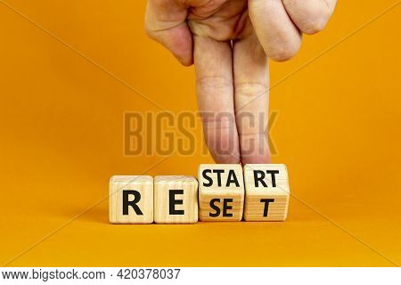 Reset And Restart Symbol. Businessman Hand Turns Cubes And Changes The Word 'reset' To 'restart'. Be
