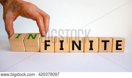 Finite Or Infinite Symbol. Businessman Turns Wooden Cubes And Changes The Word 'finite' To 'infinite