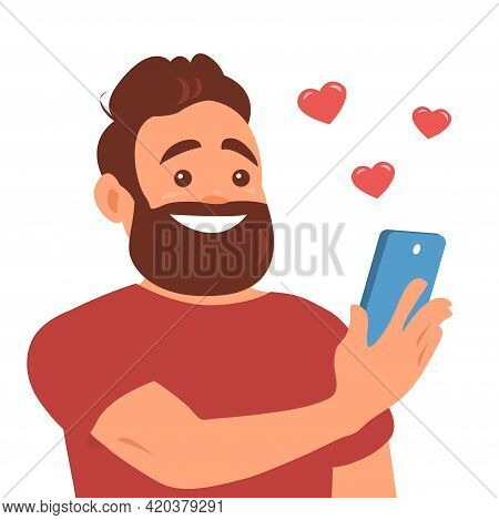 A Young Man Gets Likes On Social Networks. Smartphone In Hand. A Face With A Beard And A Happy Smile