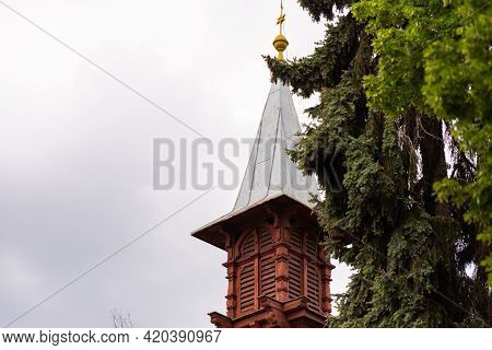 Old Wooden Tower On The Background Of A Tree With Cones. A Tower In One Of The Private Houses In Brn