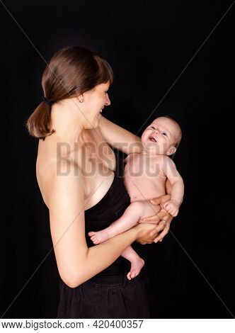 Young Woman With Cute Newborn Baby In Studio. Smiling Loving Mother Hold Beautiful Little Son In Arm
