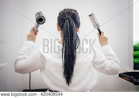 Girl With Hairdryer And Comb Stands Back