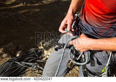 A Male Climber Ties A Safety Knot Eight On The Harness Before Climbing The Track. Climbing Equipment