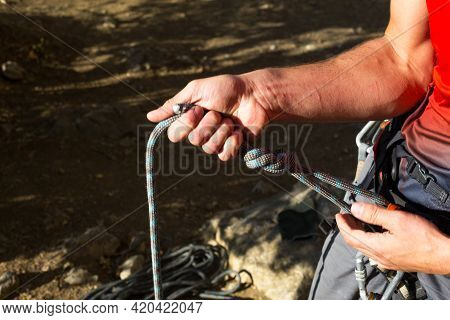 A Male Climber Ties A Safety Knot Eight On The Harness Before Climbing The Track. Climbing Equipment