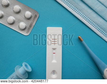 Сoronavirus 2019-ncov Antigentest With A Negative Result On A Blue Bright Background Next To A Therm