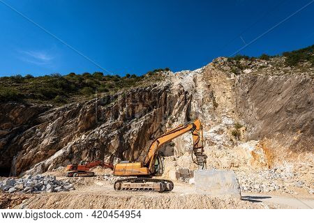Orange Tracked Excavators With Jackhammer In A White Marble Quarry. Apuan Alps (alpi Apuane), Massa 