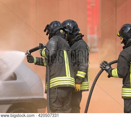 Group Of Firefighters During The Extinguishing Of The Fire Caused After The Road Accident With Prote
