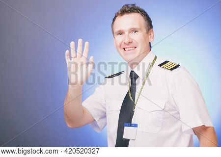 Mature smiling male pilot waving hand