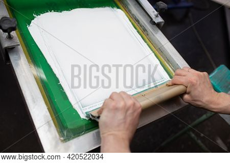 Serigraphy Silk Screen Print At Clothes Factory. Frame, Squeegee And Plastisol Color Paints.