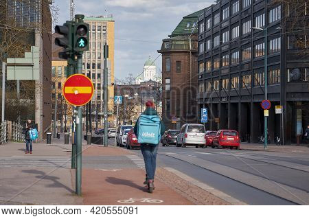 Helsinki, Finland - April 30, 2021: A Young Man With A Bag Delivering Food Wolt Rides A Scooter On T