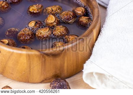 Brown Dry Soap Nuts (soapberries, Sapindus Mukorossi) In The Water With The Towel For Organic Laundr