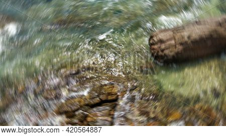 Abstract Background Of Spin Circle Radial Motion Blur Affected Shore With Rocks.