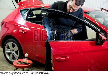 Car Service Worker Cleans Interiror With Special Brush