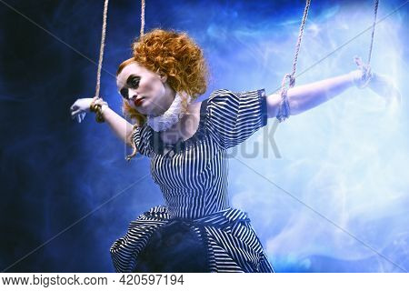 Circus and puppet theater. The actress plays a doll on strings at a performance in a puppet theater. A portrait in retro style.