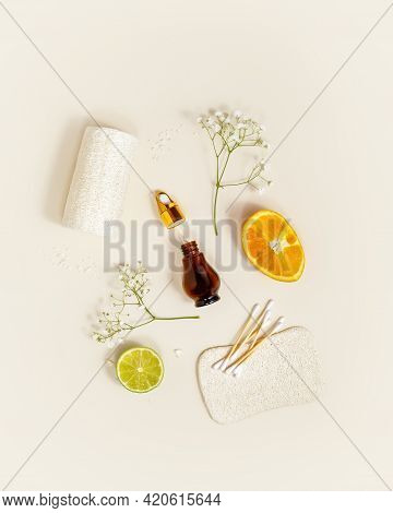 Eco Friendly Spa Composition With Bottle Of Serum, Orange, Laim And Bath Accessories On A Light Back
