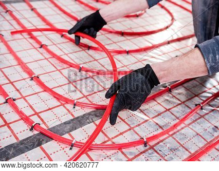 Pipefitter Install System Of Underfloor Heating System At Home