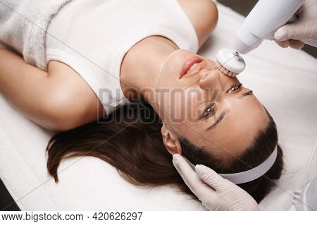 Relaxed Woman Enjoying Beauty Salon Facial Therapy. Beautician At Spa Clinic Making Brossage Brushin