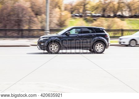 Land Rover Range Rover Evoque Rides On The City Road. Black Compact Suv Driving Along The Street In 