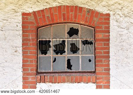 Broken Muntin Window With Shattered Glass Of Old Abandoned Building With Red Brick Wall Frame