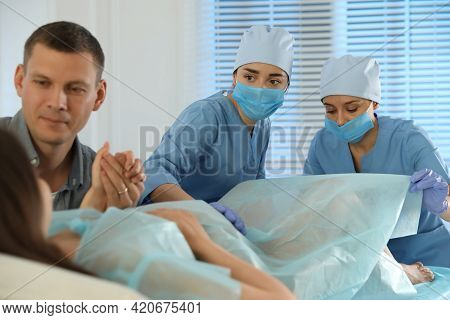 Woman Giving Child Birth In Maternity Hospital, Focus On Midwives