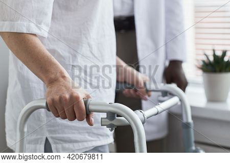 Close-up Of Senior Patient Walking With Walker Along The Hospital Ward