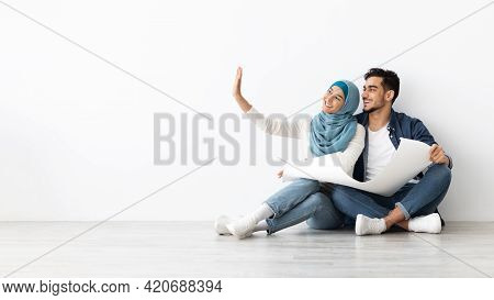 Emotional Muslim Family Thinking About Design In New House, Panorama