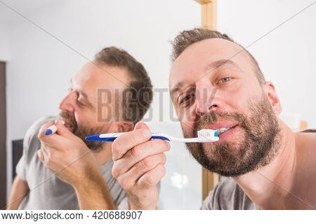 Funnny Guy Taking Care Of His Oral Hygiene, Brushing Teeth During Morning Bathroom Routine.