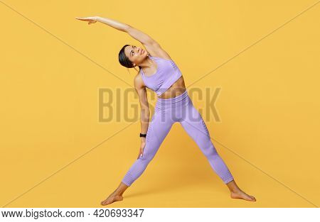 Active Lifestyle. Fit Black Woman Stretching Her Muscles Before Workout, Exrcising Indoors Over Yell
