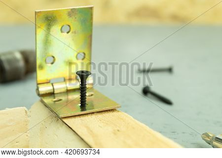 The Self-tapping Screw Is Screwed Into The Board. Screwing A Self-tapping Screw Into A Wooden Board 