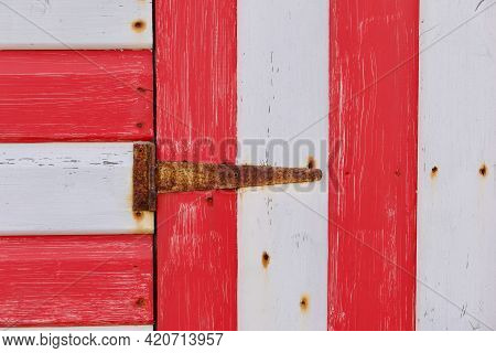 Section Of Red And White Painted Wooden Hut With Rusty Hinge