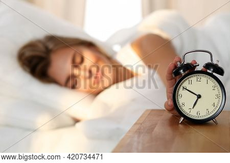 Sleepy Young Woman Stretching Hand To Ringing Alarm Willing Turn It Off. Early Wake Up, Not Getting 