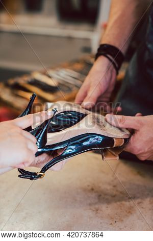 Customer bringing shoes to the shoemaker for a repair
