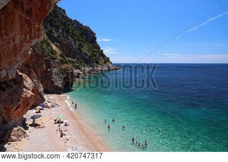 Konavle, Croatia - June 28, 2019: People Spend Vacation At Pasjaca Beach Below Cliffs In Konavle Reg