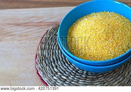 Corn Grits In A Blue Cup On A Round Wicker Stand